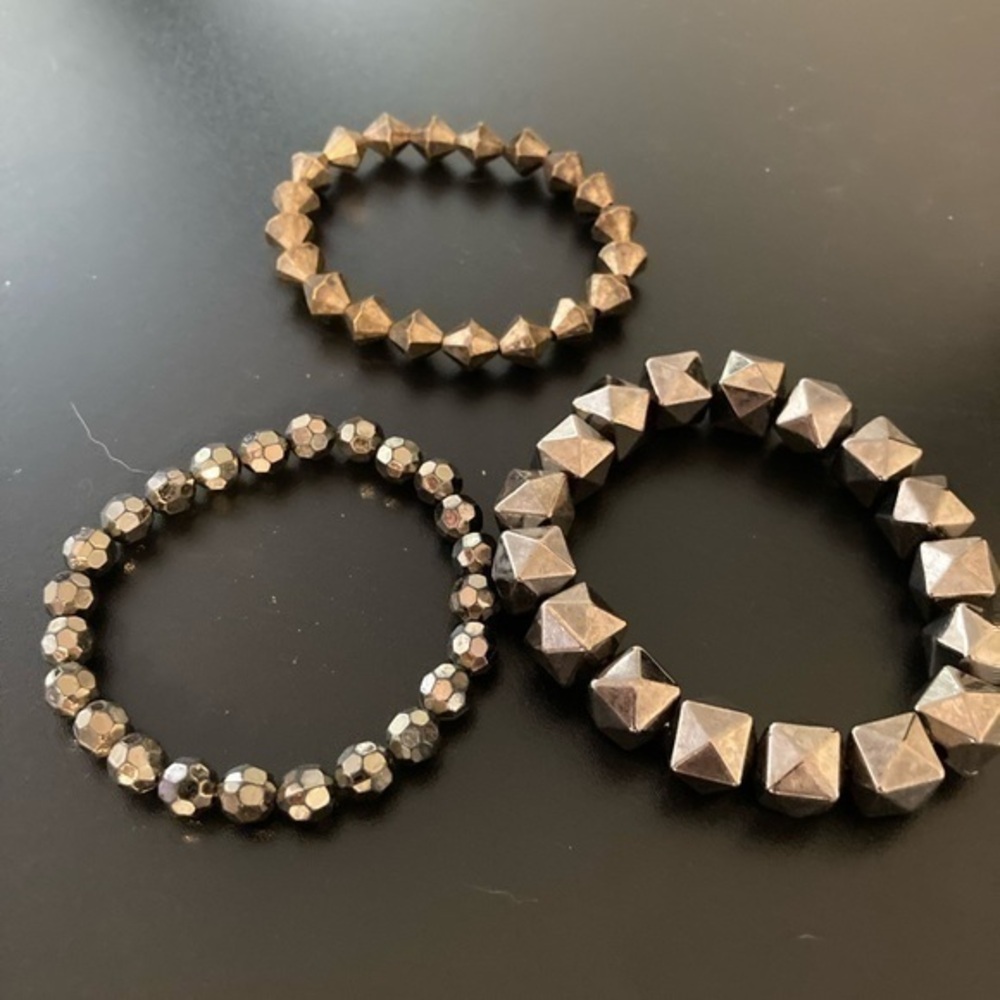 Metallic and geometric set of three bracelets.